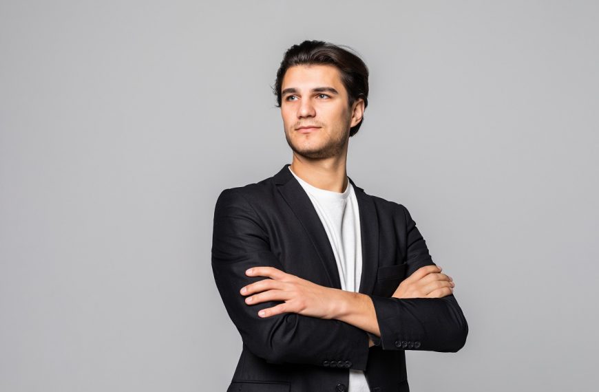 professionally dressed man with arms crossed, looking confident
